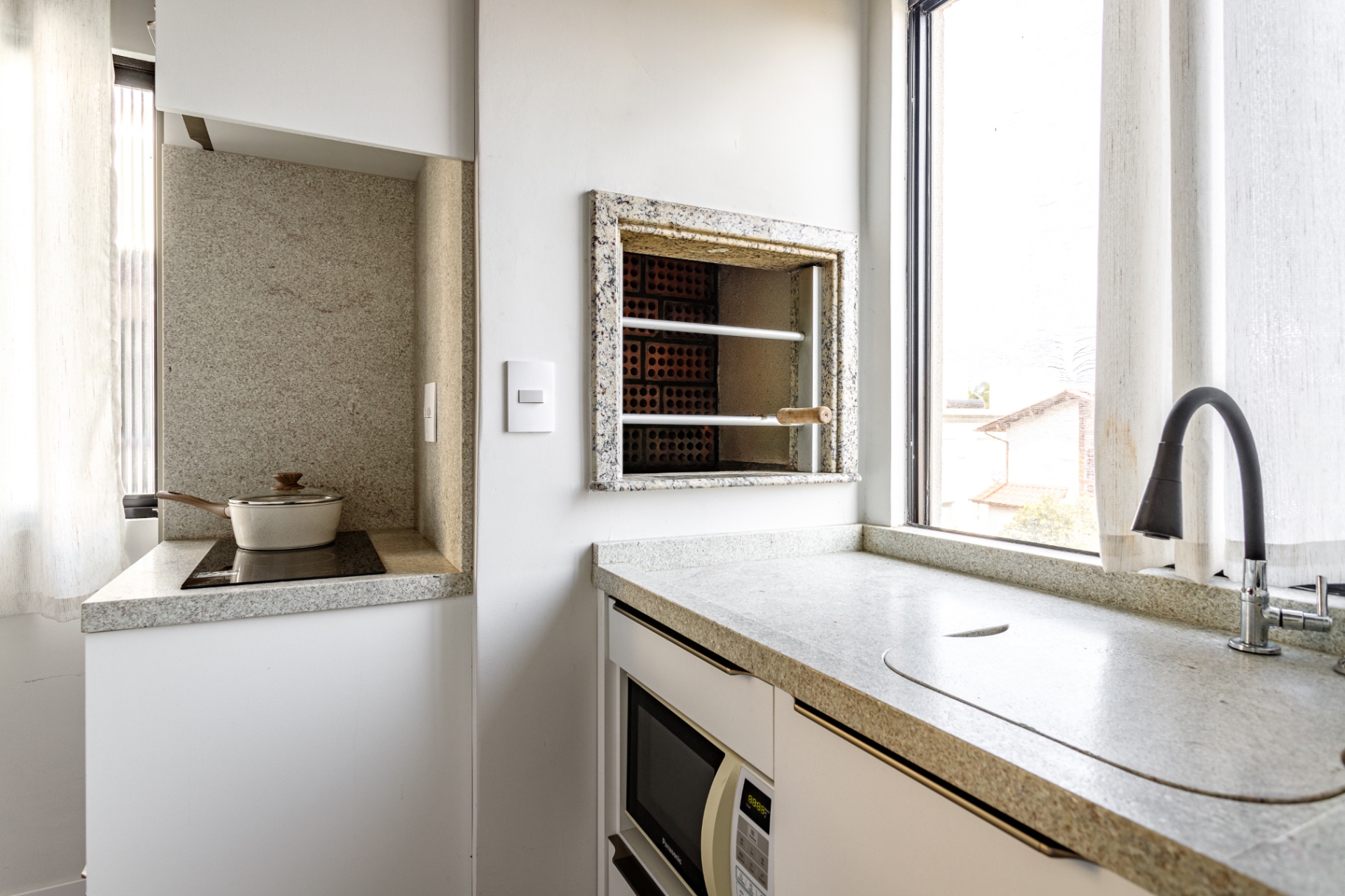 Cozinha do Loft 203 com churrasqueira embutida e micro-ondas