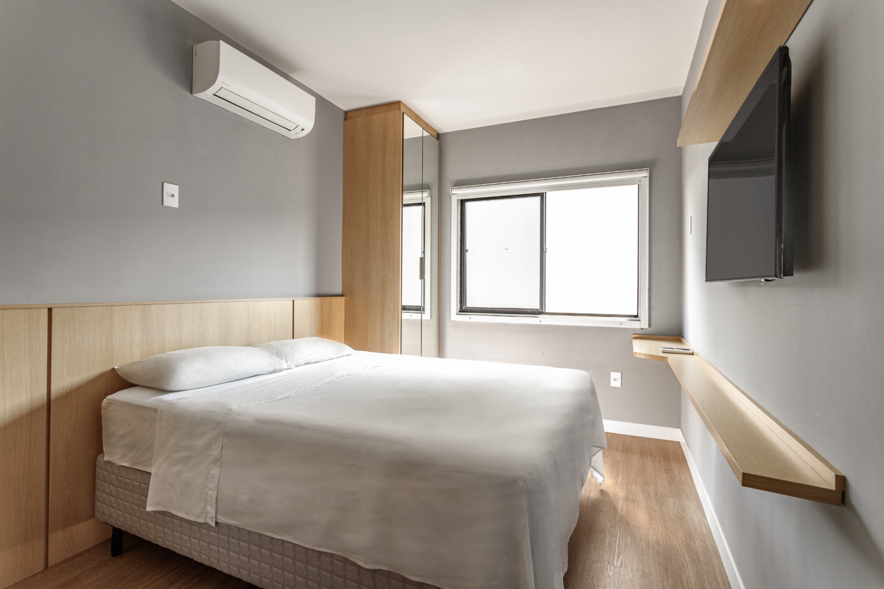 Quarto de casal do Loft 203 com TV e guarda-roupa espelhado