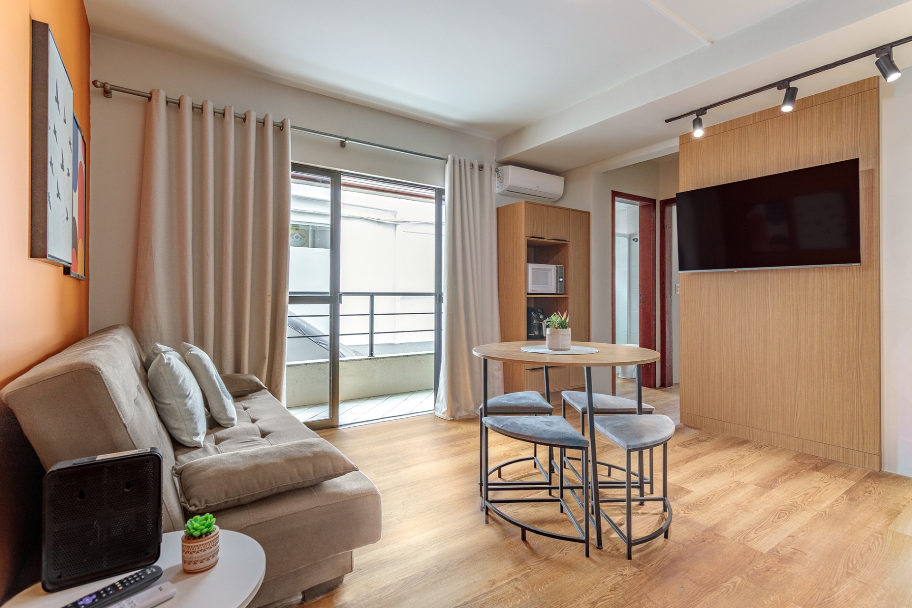 Living do Apartamento 102 com sofá, mesa e Smart TV