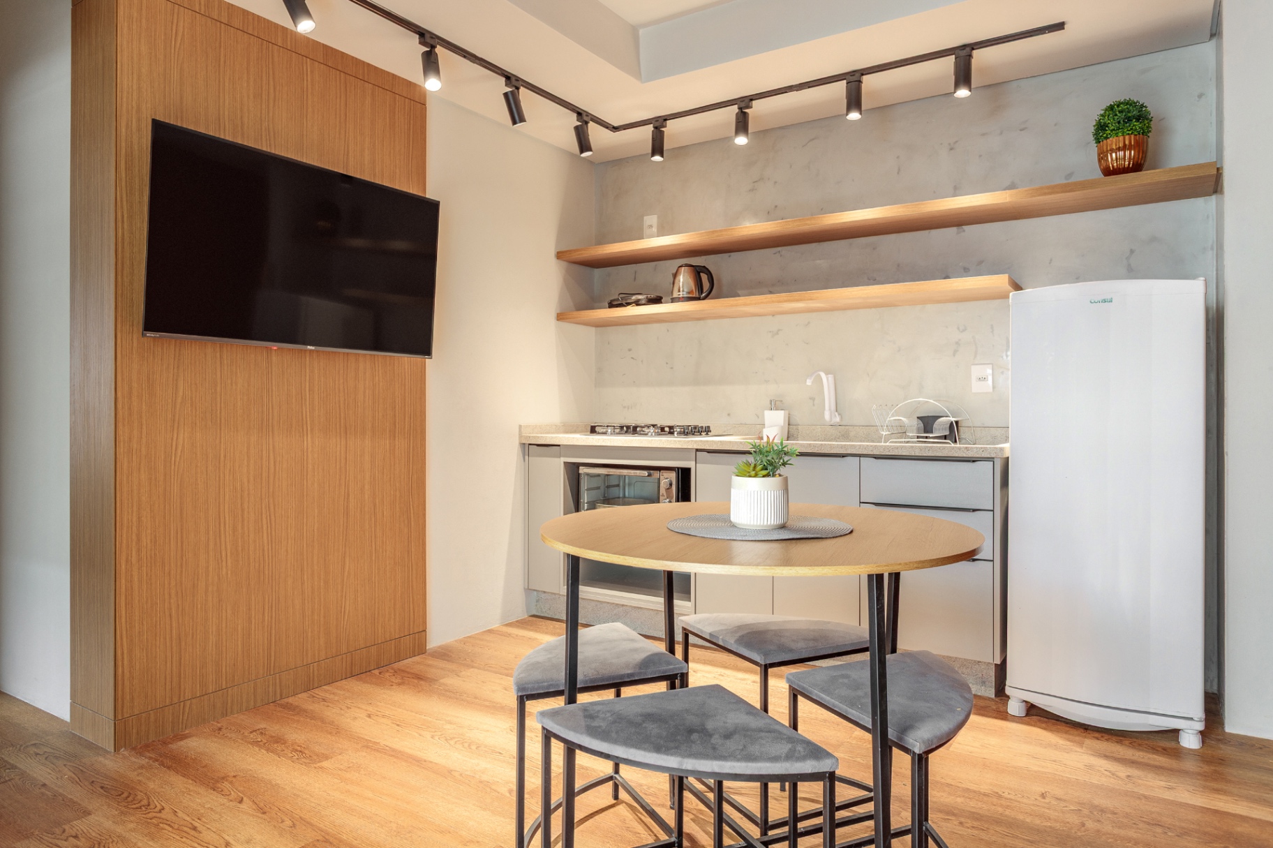 Cozinha do Apartamento 102 com geladeira e prateleiras de madeira