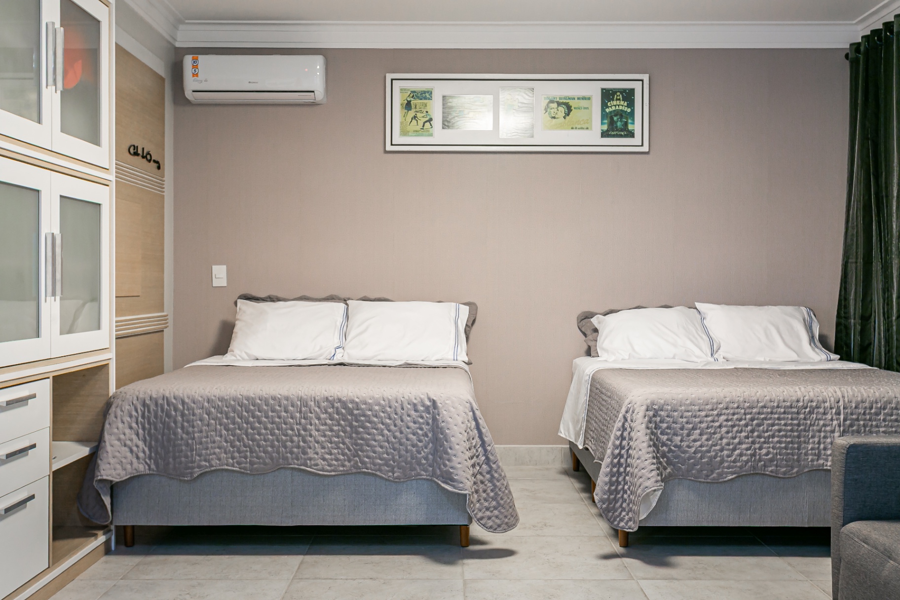 Quarto climatizado da Casa Nevi com duas camas de casal e armários