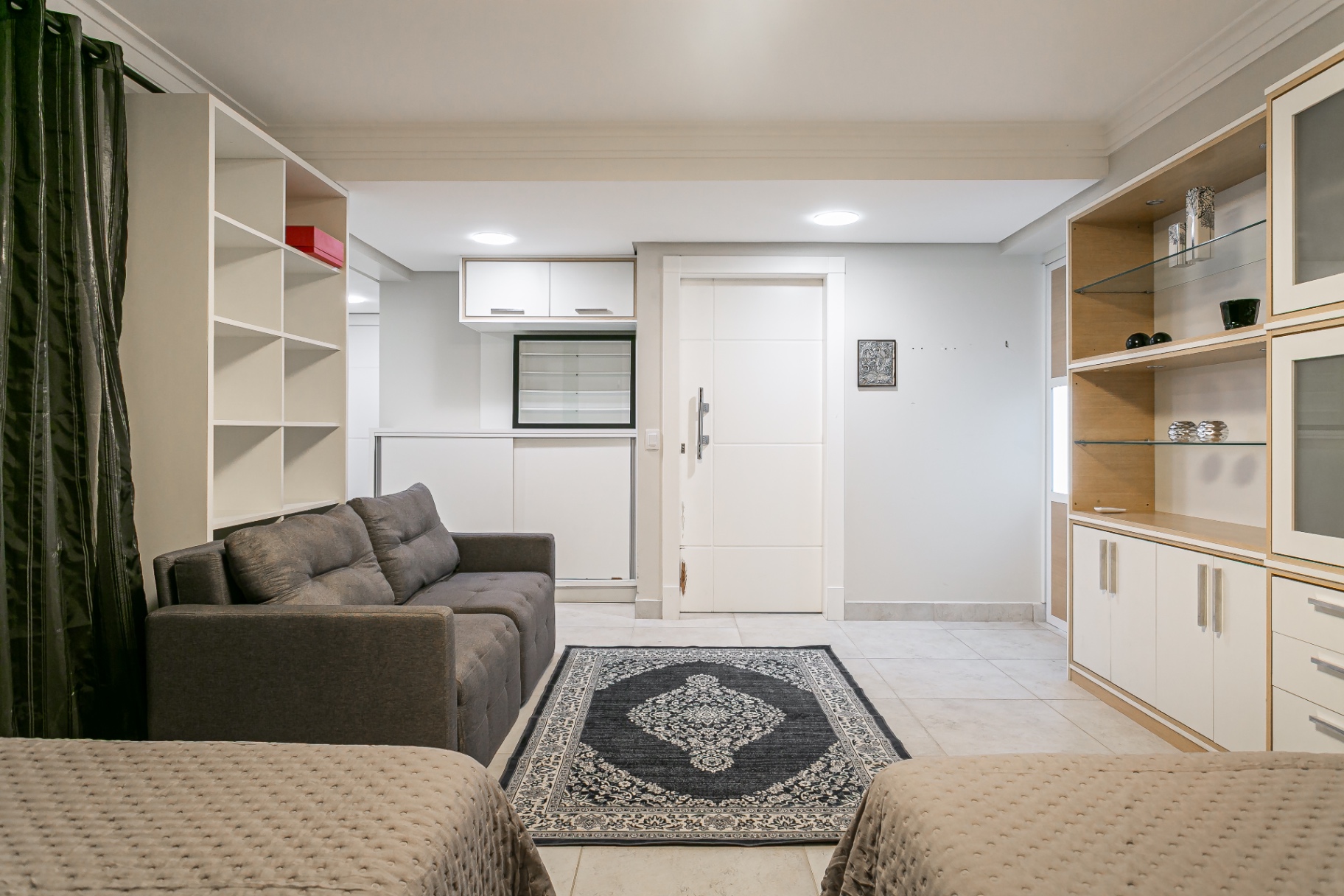Sala de estar da Casa Nevi com sofá cinza e móveis planejados