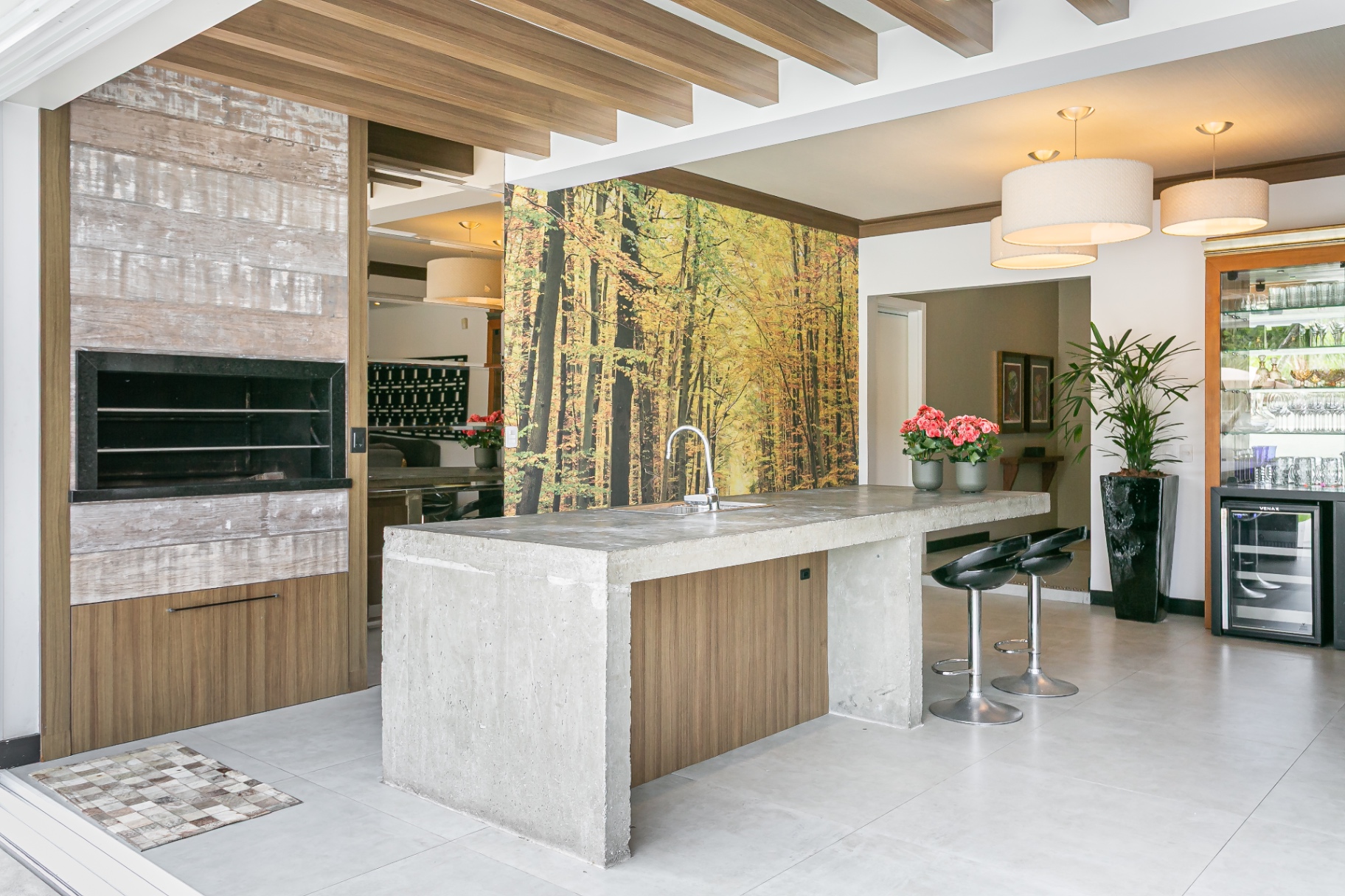 Espaço gourmet da Casa Noah com churrasqueira e balcão de concreto